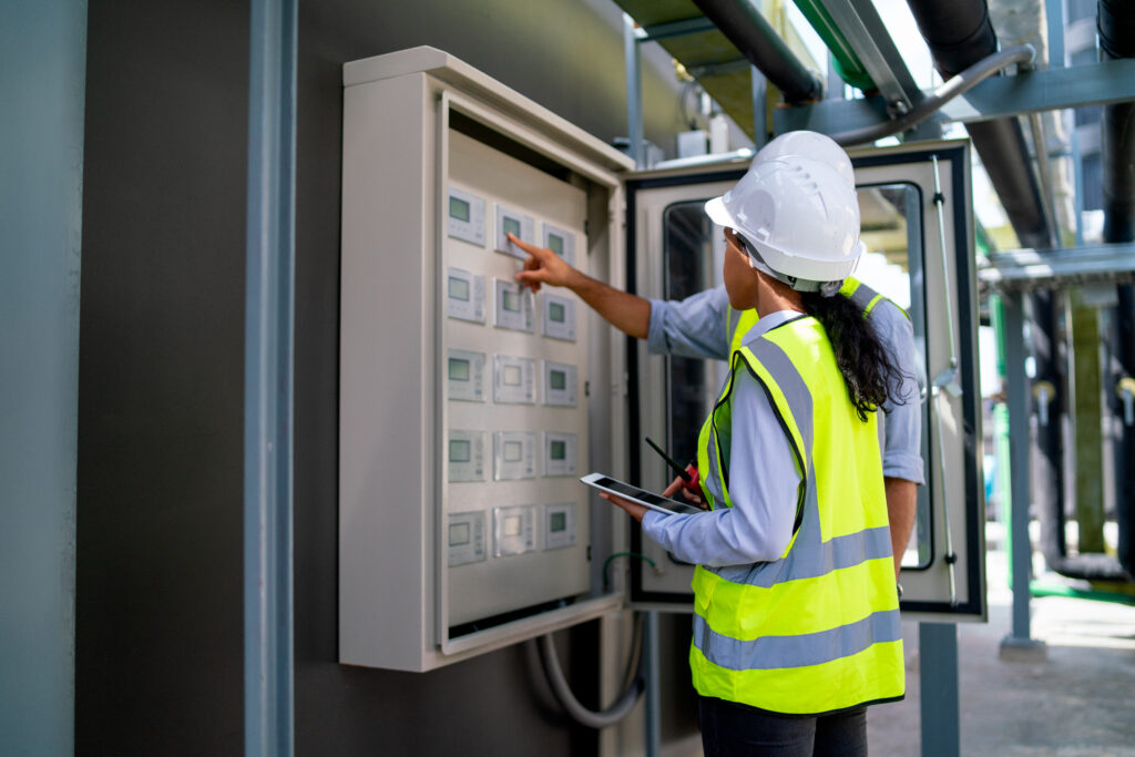 Back of professional engineer or technician workers check and maintenence the monitor network system together to prevent the problem in construction site.